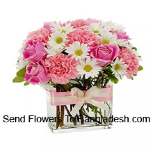 Розовые розы, розовые гвоздики и разноцветные белые сезонные цветы красиво оформлены в стеклянной вазе