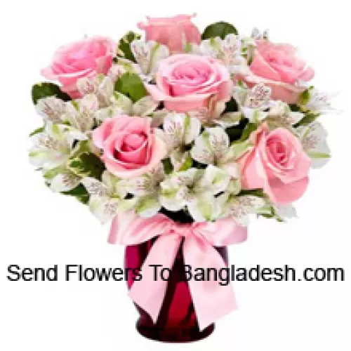Kauniisti asetellut vaaleanpunaiset ruusut ja valkoiset alstroemeriat lasimaljakossa