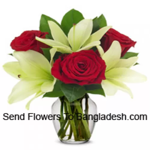 Crvene ruže i bijeli ljiljani s sezonskim punilima u staklenoj vazi