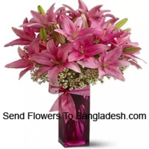 Красивые розовые лилии с папоротниками в стеклянной вазе