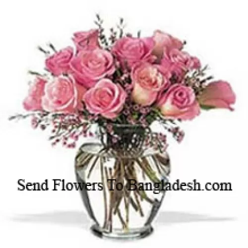Tros van 12 roze rozen met wat varens in een vaas
